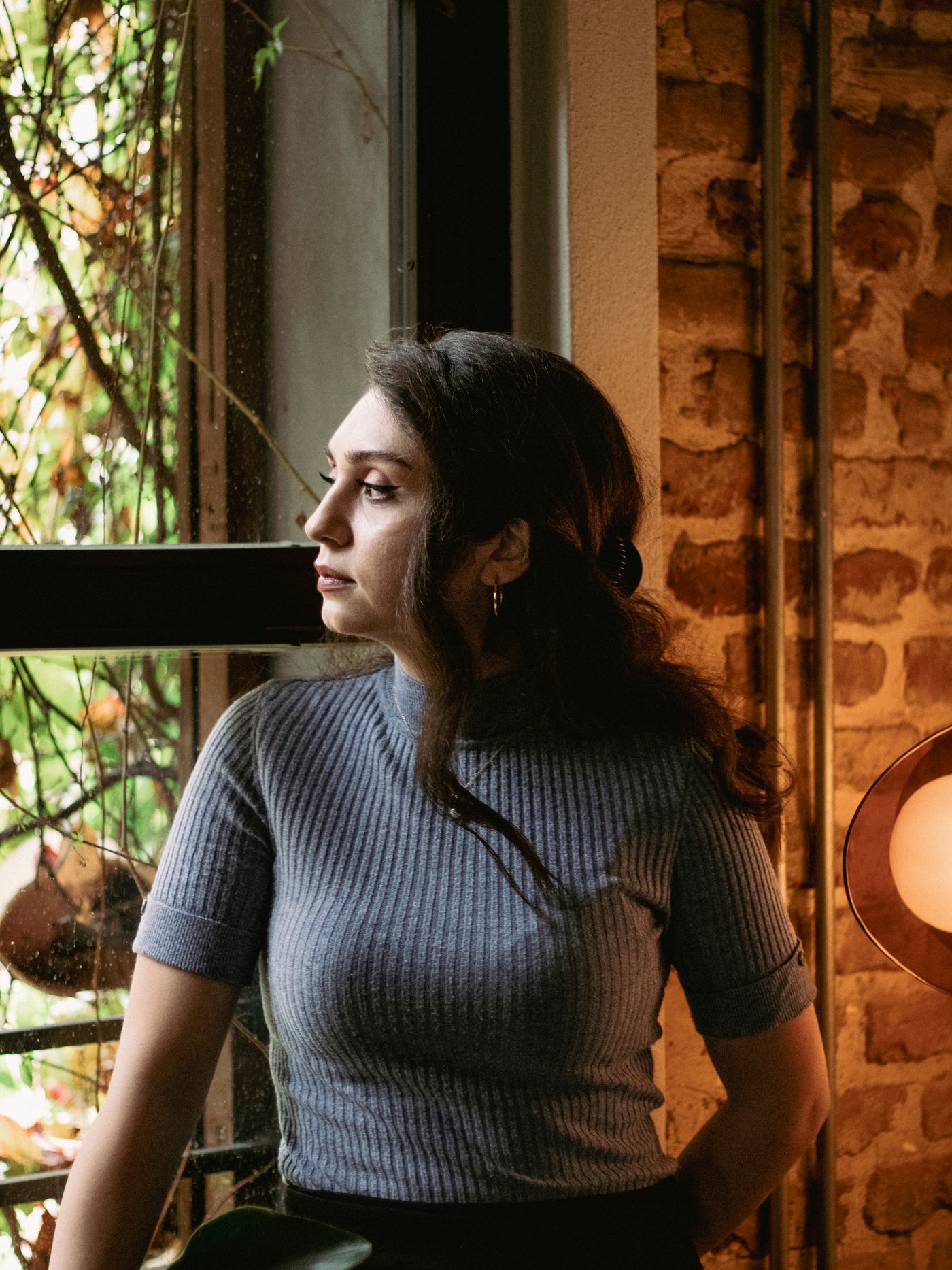 A woman reading by a window in warm light